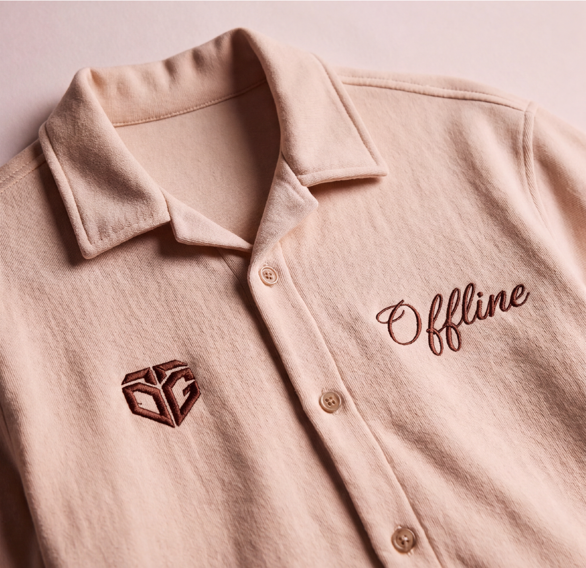 A close-up of a Oversized Boxy Fit Cream Shirt. The front features a matching embroidered geometric logo on the left chest and the word 'Offline' in script on the right chest.